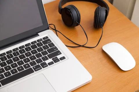 Notebook on a table with wired headphones. Podcast. Streaming. Notebook conce Stock Photos