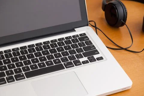 Notebook on a table with wired headphones. Podcast. Streaming. Notebook conce Stock Photos