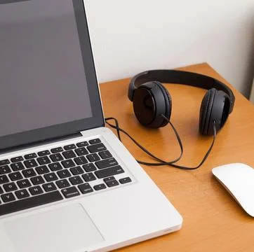 Notebook on a table with wired headphones. Podcast. Streaming. Notebook conce Stock Photos