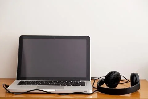 Notebook on a table with wired headphones. Podcast. Streaming. Notebook conce Stock Photos