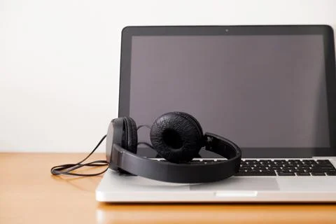 Notebook on a table with wired headphones. Podcast. Streaming. Notebook conce Stock Photos