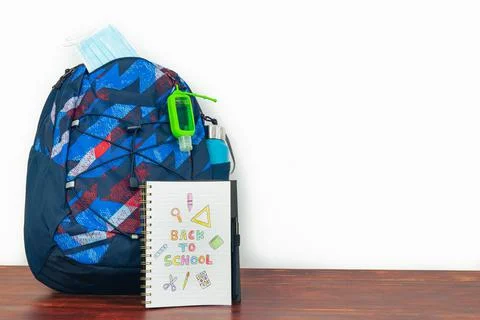 Notebook with text BACK TO SCHOOL with backpack and white background. Stock Photos