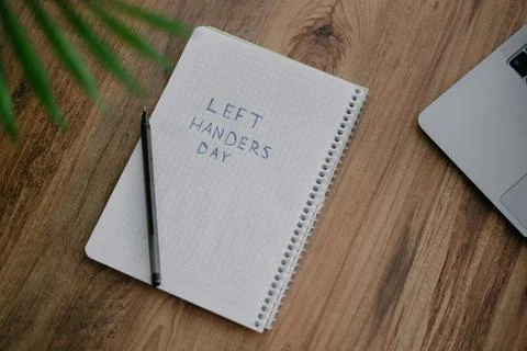 A notebook with a text Left handers day Foto stock