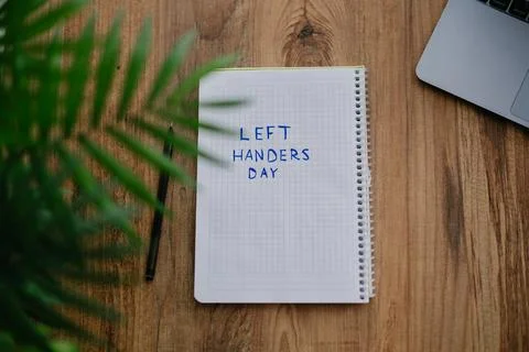 A notebook with a text Left handers day Stock Photos