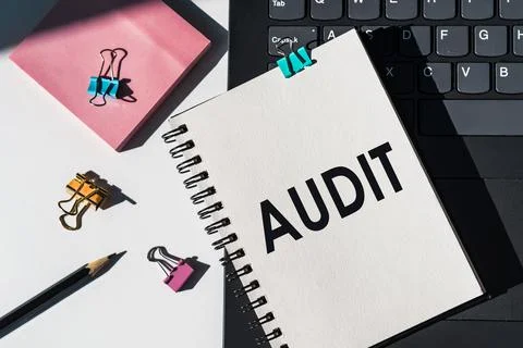 Notebook with tools and notes about "Audit" lies on laptop. Stockfoto's