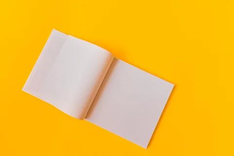 Notebook with white blank pages for notes on a yellow background. Stock Photos