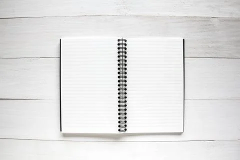 Notebook on white wooden table background. Stock Photos