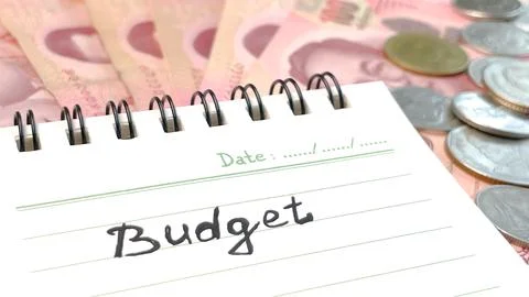A notebook with the word "Budget" written on it, Thai banknotes and coins on the Foto stock