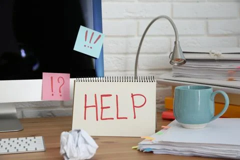 Notebook with word Help, computer and stationery on wooden table at workplace Stock Photos