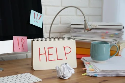 Notebook with word Help, computer and stationery on wooden table at workplace Stock Photos