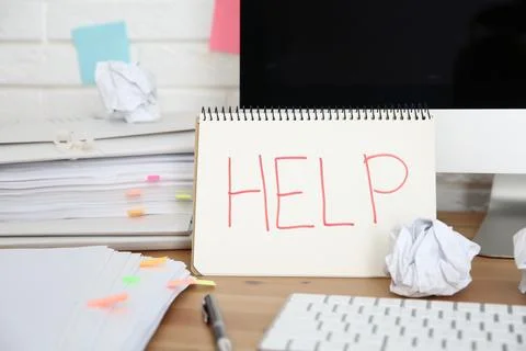 Notebook with word Help, computer and stationery on wooden table at workplace Stock Photos