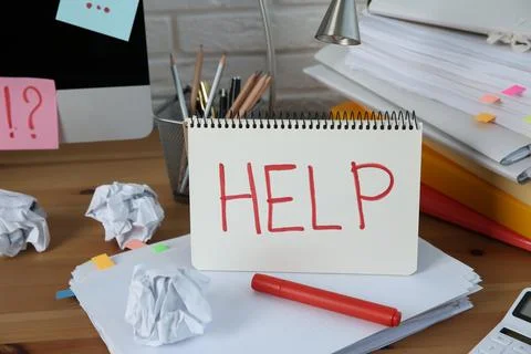 Notebook with word Help, computer and stationery on wooden table at workplace Stock Photos
