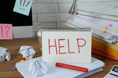 Notebook with word Help, computer and stationery on wooden table at workplace Stock Photos