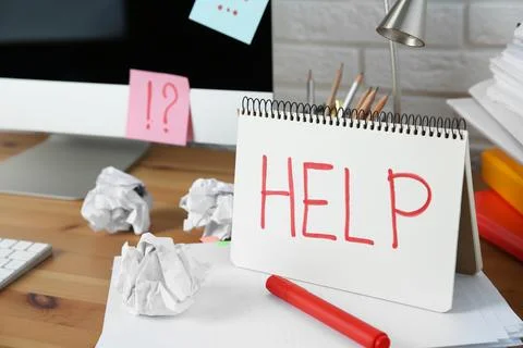 Notebook with word Help, computer and stationery on wooden table at workplace Stock Photos