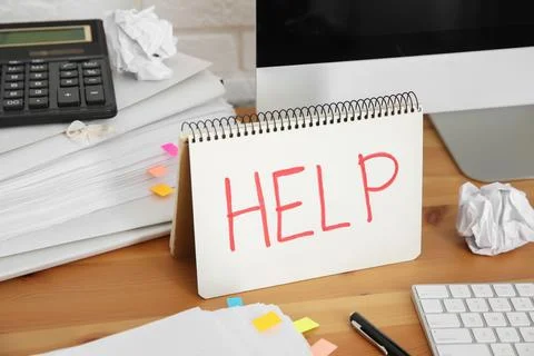 Notebook with word Help, computer and stationery on wooden table at workplace Stock Photos