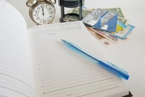 Notebook with the word plan on the office table with stationery, clock, pen,  Stock Photos