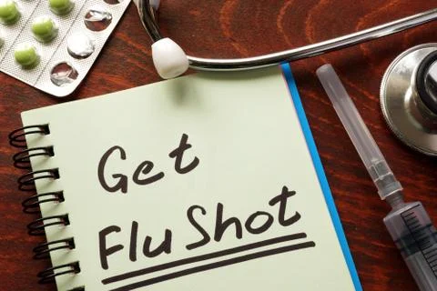 Notebook with the words Get Flu shot on the table. Stock Photos