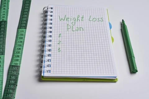 A notebook with the words weight loss plan on it Stock Photos