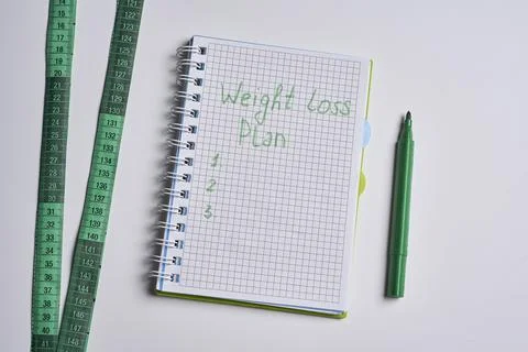 A notebook with the words weight loss plan on it Stock Photos