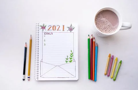 Notebook for writing New Year's resolutions on a table with colored pencils o Stock-Fotos