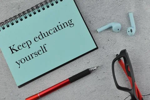 Notebook written with text KEEP EDUCATING YOURSELF Stock Photos