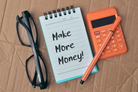Notebook written with text MAKE MORE MONEY!. Stock Photos