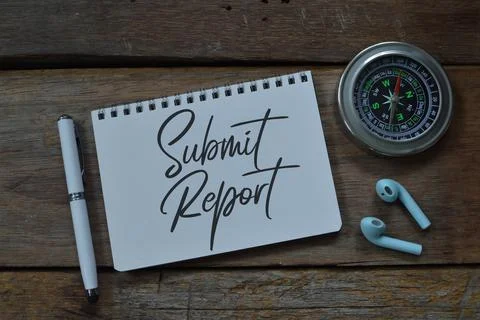 Notebook written with text SUBMIT REPORT over wooden background. Stock Photos