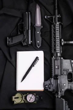 Notebook,pen,gun,knife,rifle and compass.Top view. Stock Photos