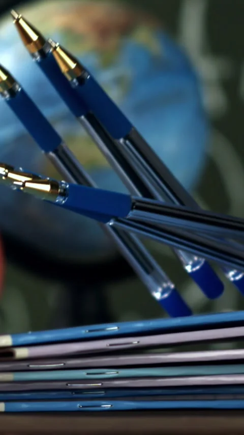 Notebooks and pens fall on the school desk. Filmed on a high-speed camera at Stock Footage 335371951