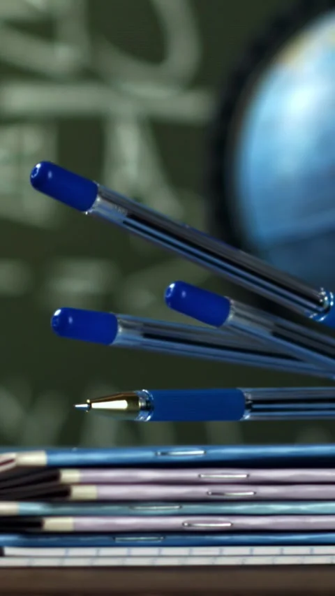 Notebooks and pens fall on the school desk. Filmed on a high-speed camera at Stock Footage 335373212