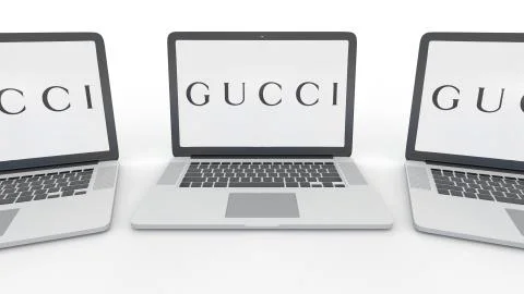 Notebooks with Gucci logo on the screen. Computer technology conceptual Stock Illustration