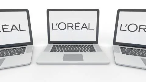 Notebooks with L'Oreal logo on the screen. Computer technology conceptual Stock Illustration