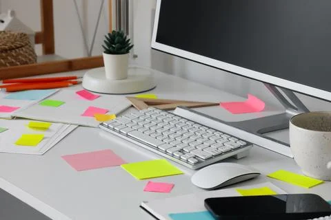Notebooks with sticky notes and computer on desk in office Stock Photos