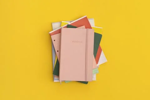 Notebooks on yellow background. Top view. Flat lay. Back to school concept. Stock Photos