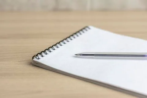 Notepad and ballpoint pen on the table close-up with a copy of the space. Stock Photos