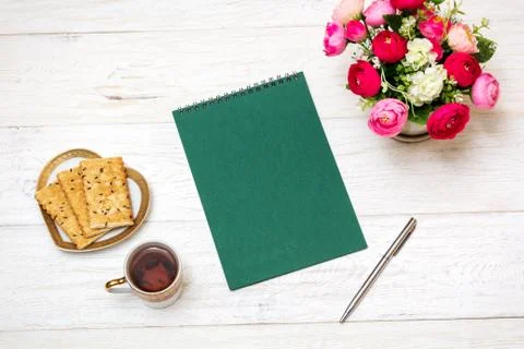 Notepad and cup of tea on white boards Stock Photos