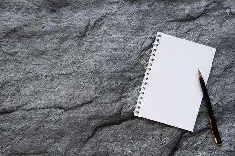 Notepad and pen on stone background. Stock Photos