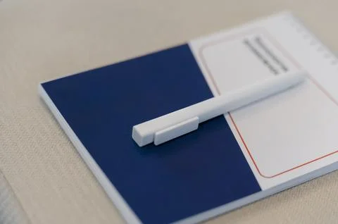 Notepad and pen on a textured surface, branding visible on stationery Stock Photos