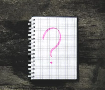 Notepad and question mark on the table Stock Photos