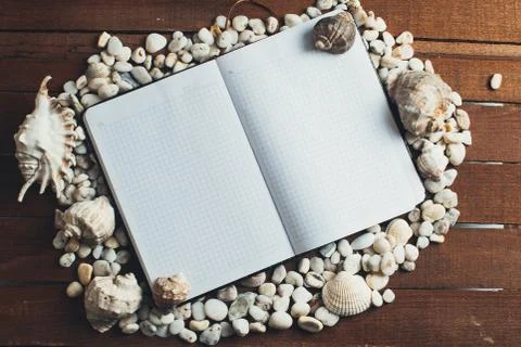 Notepad around him shells Stock Photos