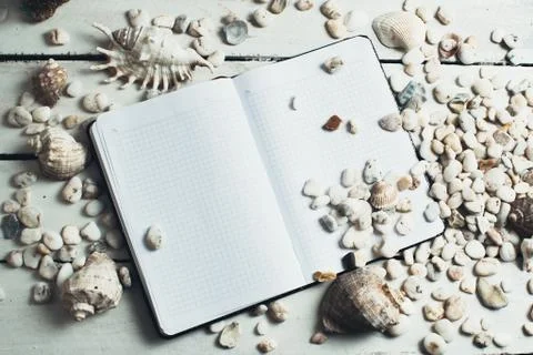 Notepad around him shells Stock Photos