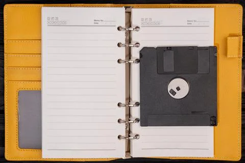 Notepad with black old floppy disk for computer Stock Photos