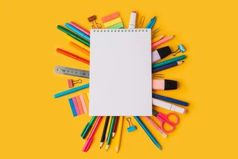 Notepad with blank sheets on school supplies on yellow background Stock Photos
