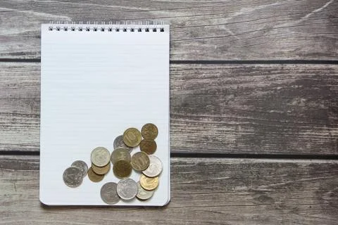 Notepad with a blank white sheet in a checker paper with russian coins lies o Stock Photos