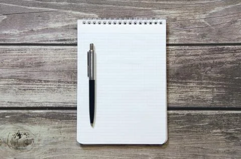 Notepad with a blank white sheet in a checker paper with ball pen lies on the Foto stock