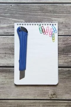 Notepad with a blank white sheet in a checker paper and with stationery knife Foto stock