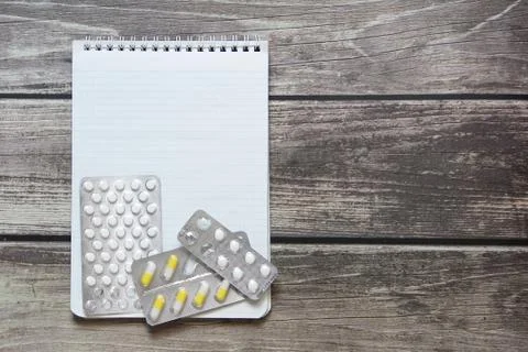 Notepad with a blank white sheet in a checker paper with pills in a blister l Foto stock