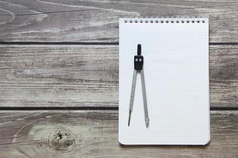 Notepad with a blank white sheet in a checker paper with compass lies on the  Stock Photos