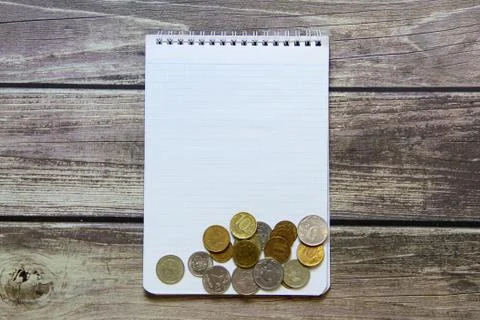 Notepad with a blank white sheet in a checker paper with russian coins lies o Stock Photos