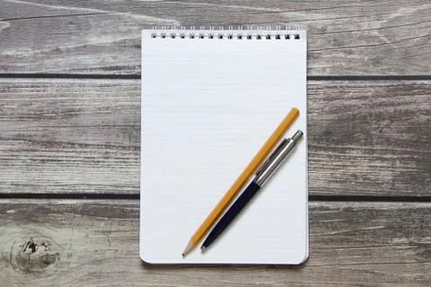 Notepad with a blank white sheet in a checker paper with ball pen and simple Stock Photos